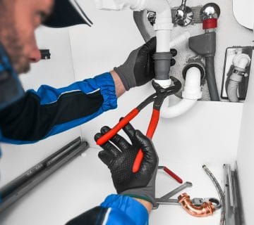 Plumber,Working,In,Kitchen,,Repair,Man,Service,,Repairing,Leaking,Water